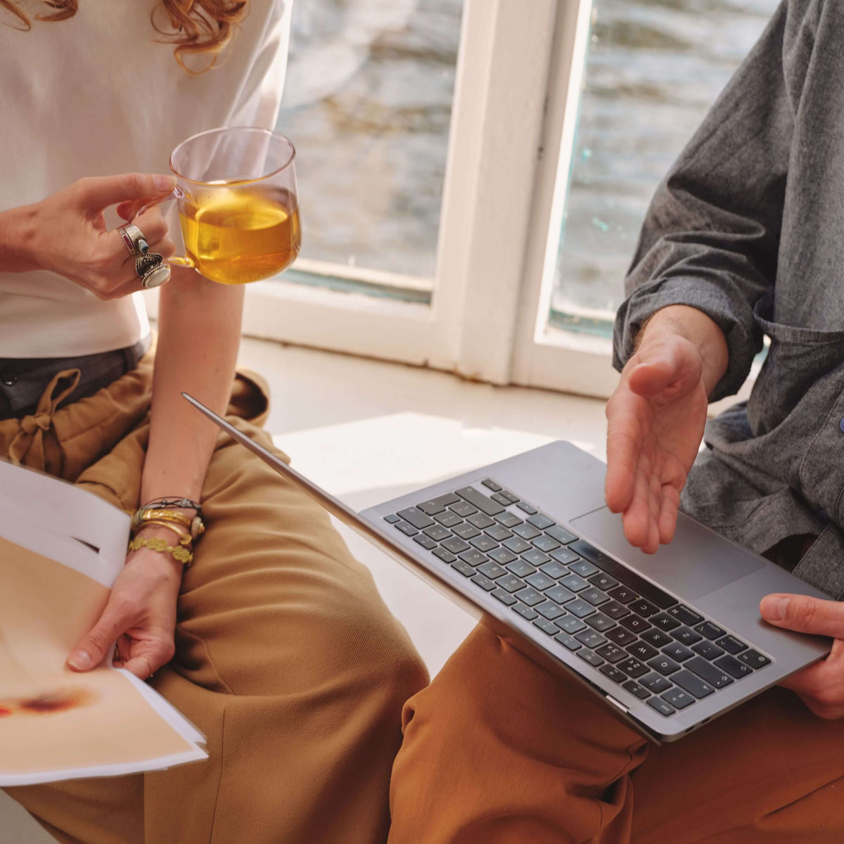 two people working on laptop with cup of tea